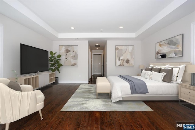 bedroom featuring a tray ceiling, wood finished floors, and recessed lighting