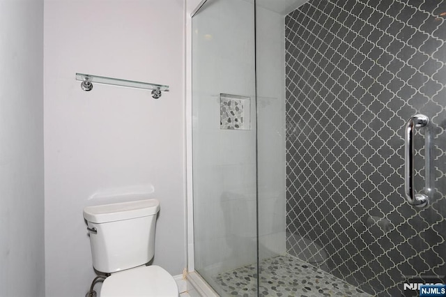 bathroom with toilet and tiled shower