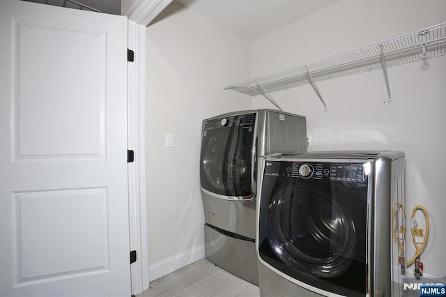 laundry room featuring laundry area, separate washer and dryer, and baseboards