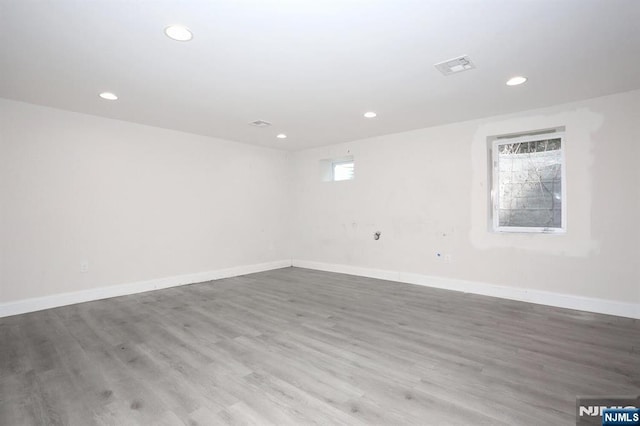 below grade area featuring visible vents, baseboards, wood finished floors, and recessed lighting