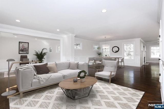 living area with wainscoting, wood finished floors, crown molding, a decorative wall, and recessed lighting