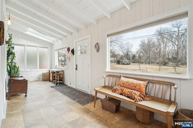 sunroom / solarium featuring lofted ceiling with beams and a healthy amount of sunlight