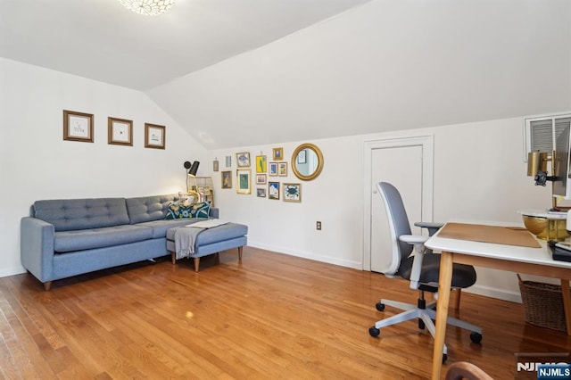 office area featuring lofted ceiling, light wood finished floors, and baseboards