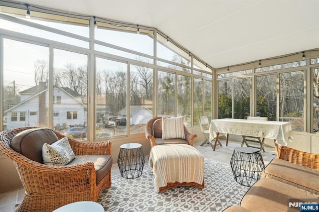 sunroom / solarium featuring a healthy amount of sunlight and vaulted ceiling