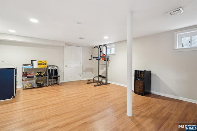 exercise area featuring light wood-type flooring, visible vents, and baseboards