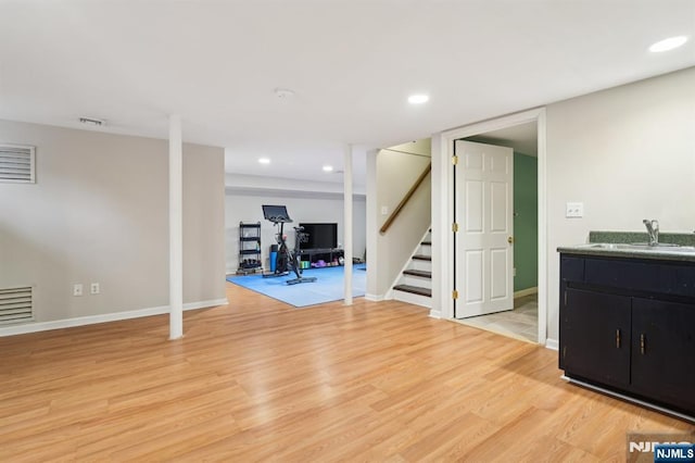 exercise area with light wood-type flooring, a sink, visible vents, and recessed lighting