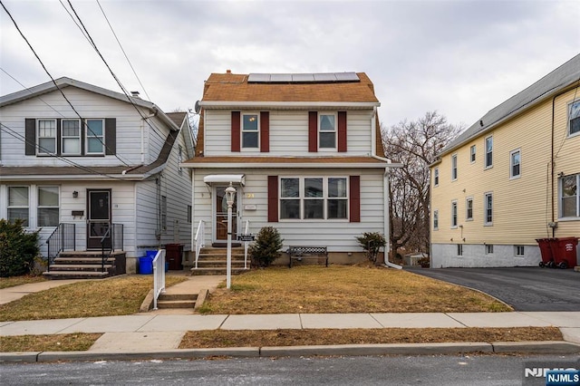 view of front of property featuring a shingled roof, crawl space, and solar panels