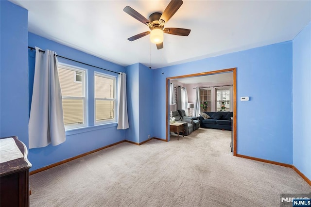 unfurnished bedroom featuring carpet, a ceiling fan, and baseboards