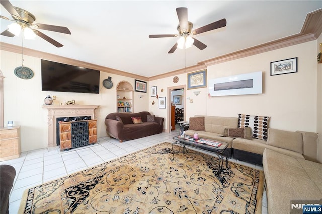 living room featuring light tile patterned flooring, a ceiling fan, a fireplace, and crown molding