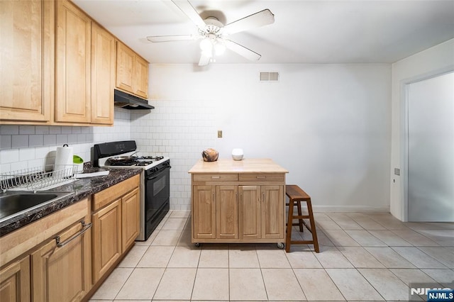 kitchen with black gas range oven, visible vents, under cabinet range hood, and light tile patterned floors