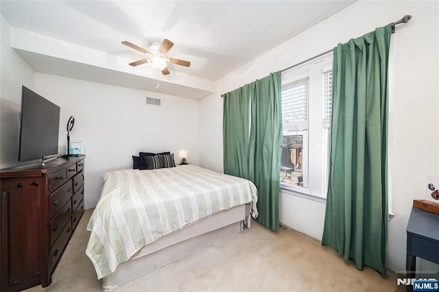 bedroom featuring visible vents, light colored carpet, and ceiling fan