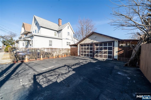 view of side of property with an outbuilding and fence