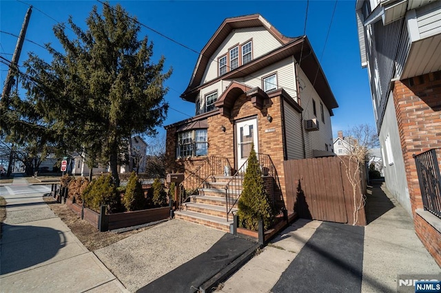 view of front of home with brick siding and fence