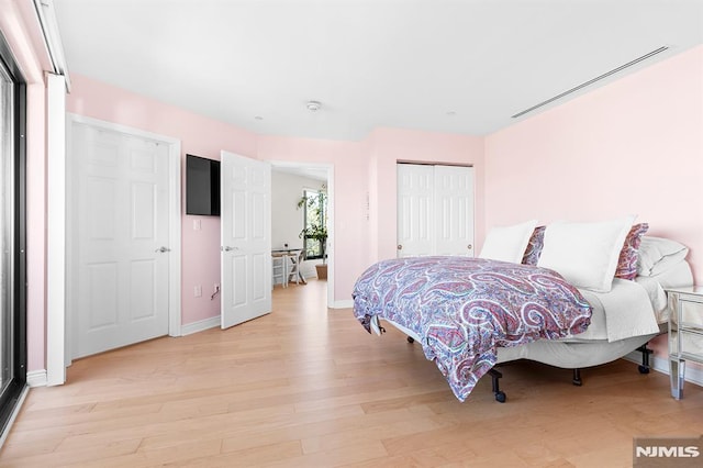 bedroom with a closet, baseboards, and light wood-style flooring