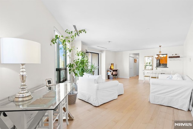 living area with an inviting chandelier and light wood finished floors