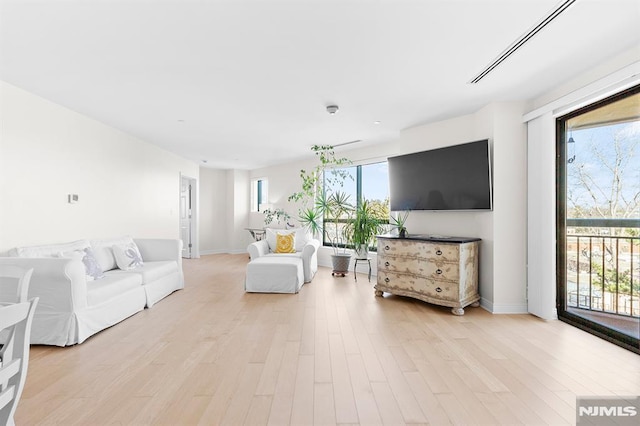 living room with light wood-style flooring and baseboards