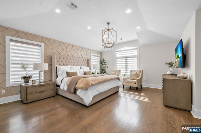 bedroom featuring visible vents, lofted ceiling, an accent wall, wood finished floors, and recessed lighting