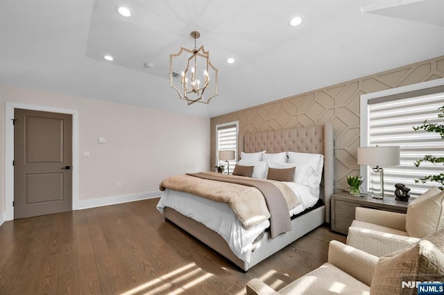 bedroom with a notable chandelier, dark wood finished floors, recessed lighting, an accent wall, and baseboards