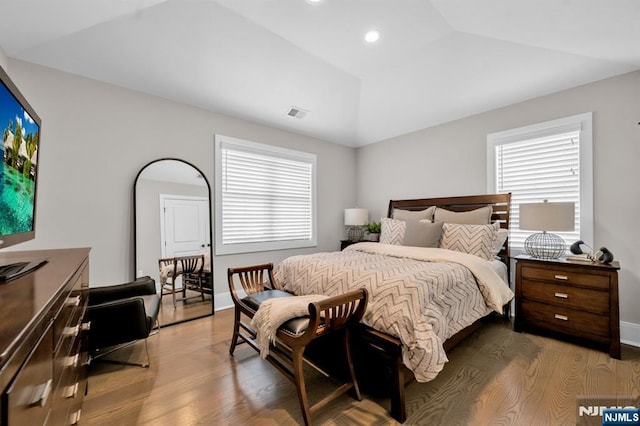 bedroom with lofted ceiling, baseboards, and wood finished floors