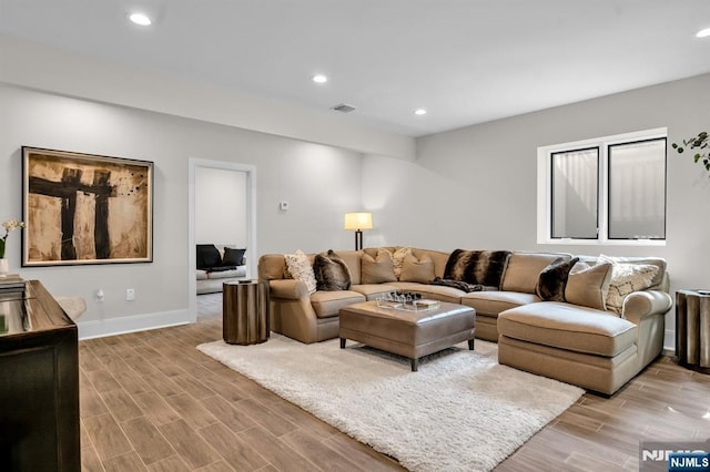 living room with wood tiled floor, visible vents, and recessed lighting