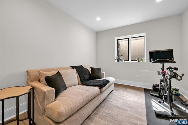 exercise area featuring recessed lighting, wood finished floors, and baseboards