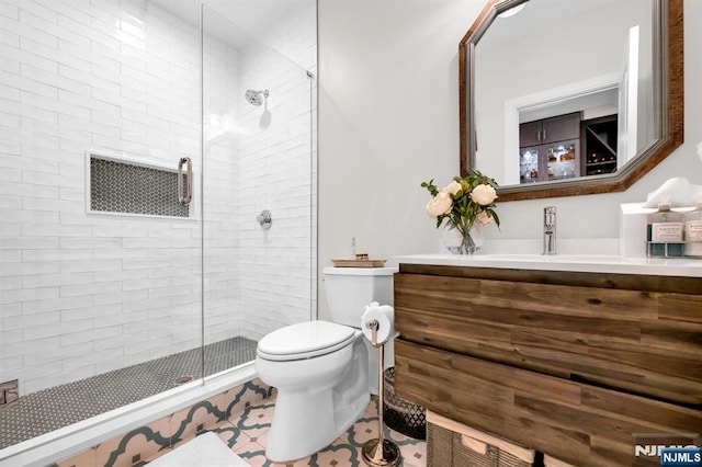 full bath featuring a stall shower, vanity, and toilet