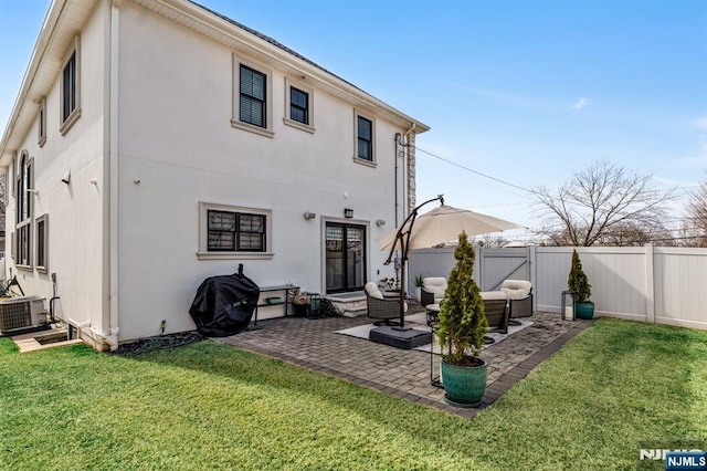 rear view of house with central air condition unit, a yard, a fenced backyard, and a patio