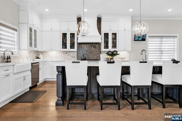 kitchen featuring stainless steel dishwasher, custom exhaust hood, a sink, and a wealth of natural light