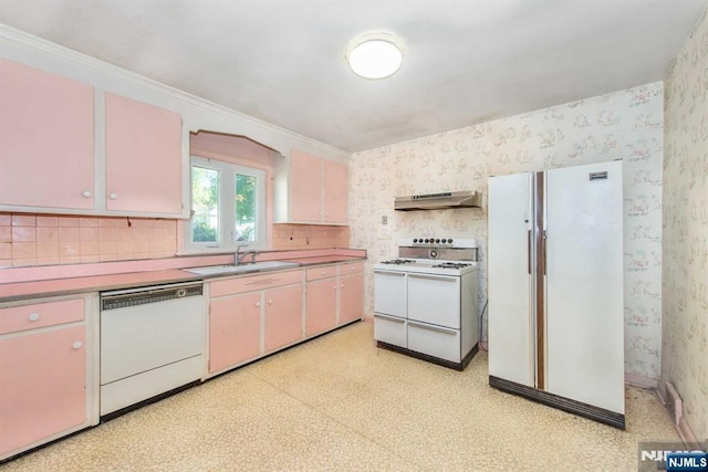 kitchen featuring under cabinet range hood, white appliances, a sink, light floors, and wallpapered walls