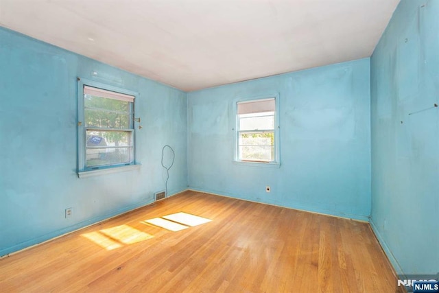 spare room with visible vents and wood finished floors