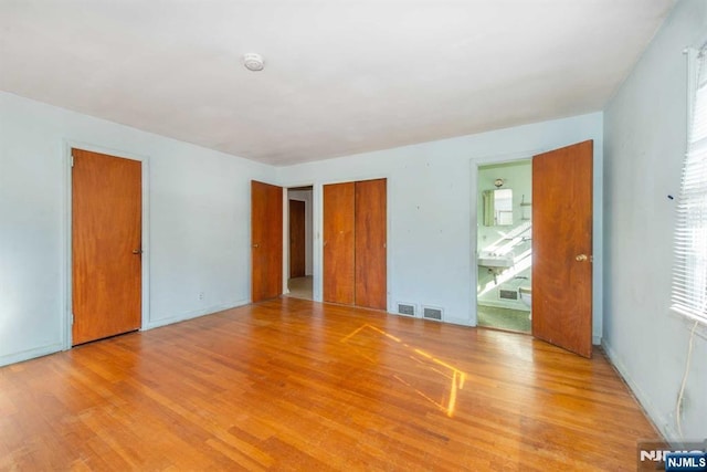 empty room featuring light wood-style floors and visible vents