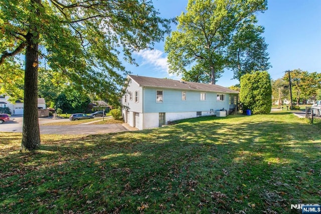 view of yard with a garage and driveway