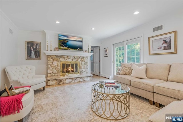 living room featuring crown molding, a fireplace, recessed lighting, visible vents, and baseboards