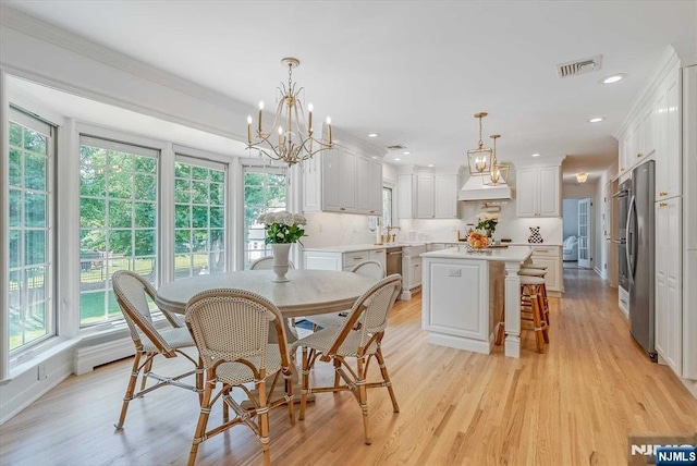 dining room featuring crown molding, light wood finished floors, visible vents, and recessed lighting