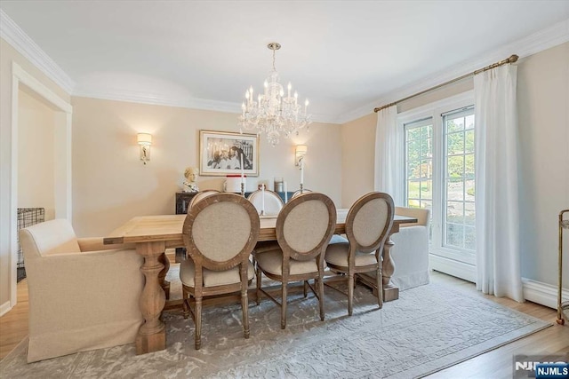 dining area featuring a notable chandelier, crown molding, baseboards, and wood finished floors