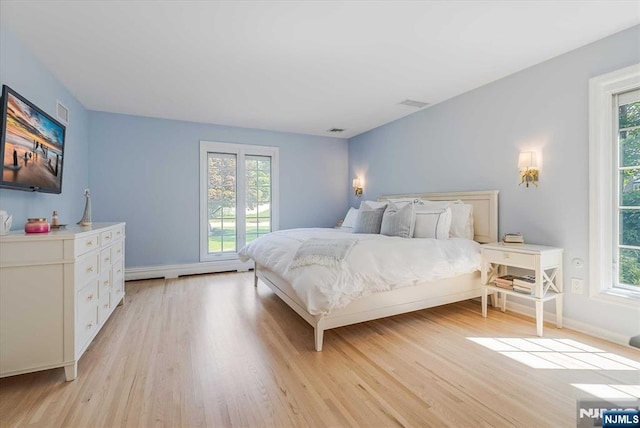 bedroom with visible vents, light wood-style flooring, and baseboards