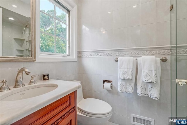 full bath featuring toilet, visible vents, and tile walls