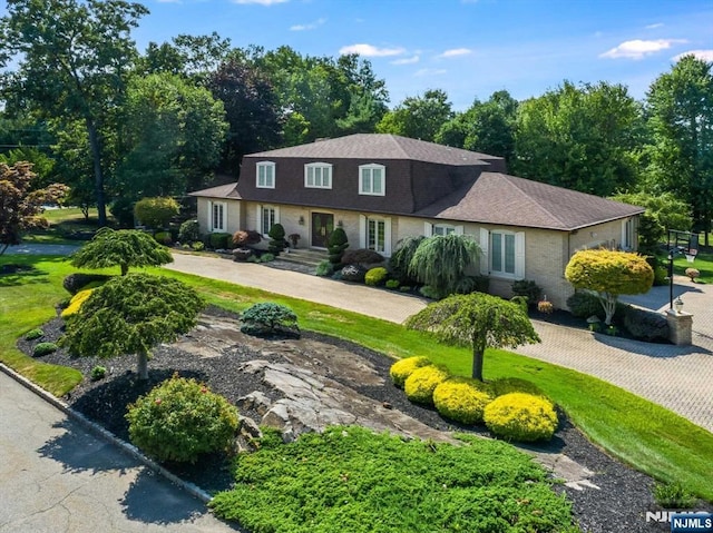 view of front of house with driveway and roof with shingles