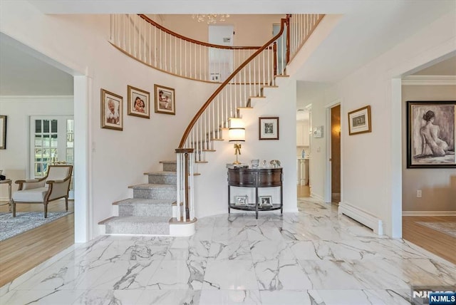 stairway with baseboards, ornamental molding, marble finish floor, a high ceiling, and a baseboard heating unit