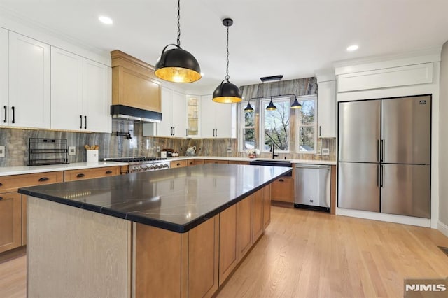 kitchen with range hood, light wood-style flooring, stainless steel appliances, white cabinetry, and backsplash