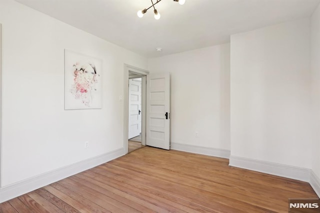 empty room with baseboards and light wood-style floors