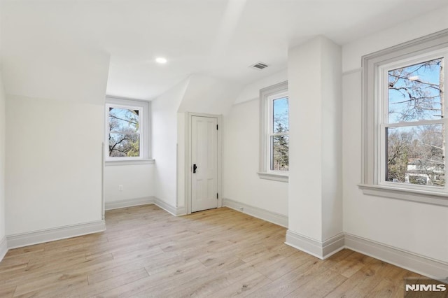 bonus room featuring lofted ceiling, a healthy amount of sunlight, baseboards, and light wood finished floors