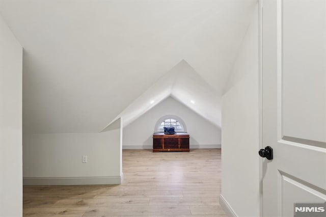 bonus room with lofted ceiling, wood finished floors, and baseboards