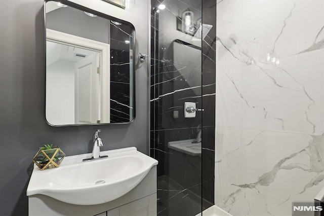 bathroom featuring a walk in shower and vanity