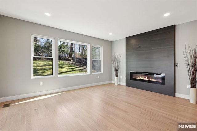 unfurnished living room featuring visible vents, baseboards, light wood-type flooring, recessed lighting, and a fireplace