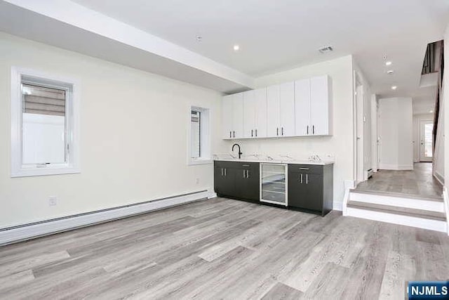 bar featuring wine cooler, recessed lighting, a baseboard radiator, wet bar, and light wood-type flooring