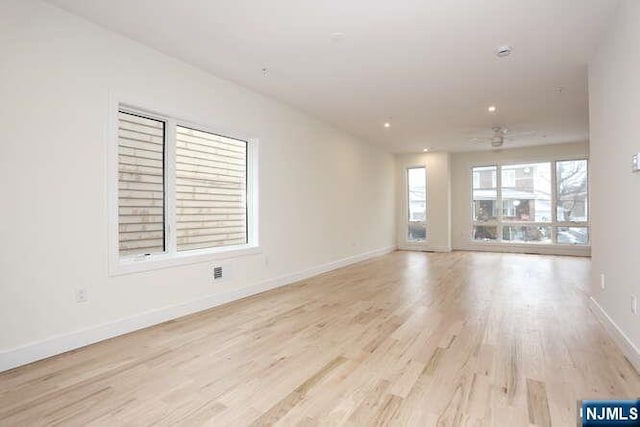 empty room with light wood-style flooring and baseboards