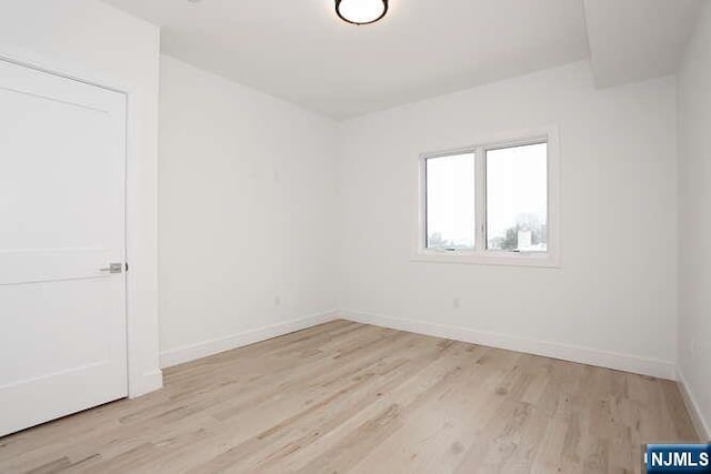 empty room with baseboards and wood finished floors