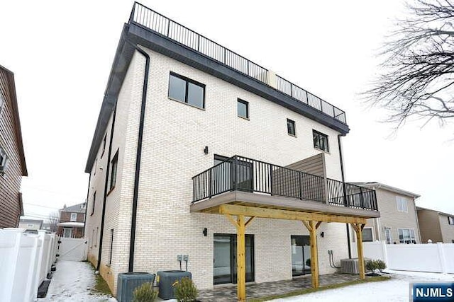 rear view of property featuring brick siding, a fenced backyard, washer and clothes dryer, and central air condition unit