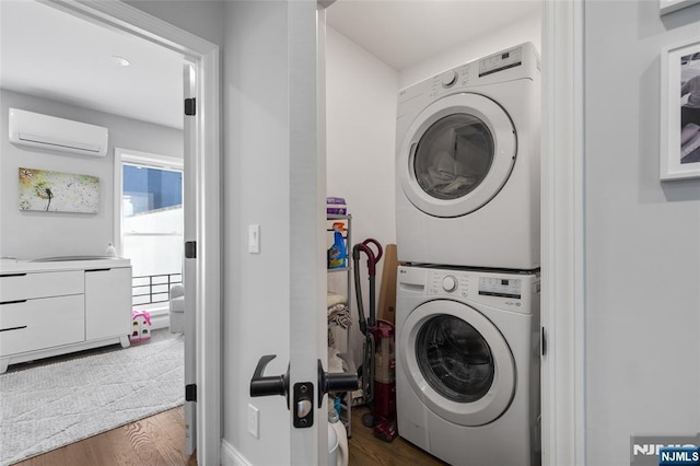 clothes washing area with dark wood-type flooring, stacked washer / drying machine, laundry area, and a wall mounted AC